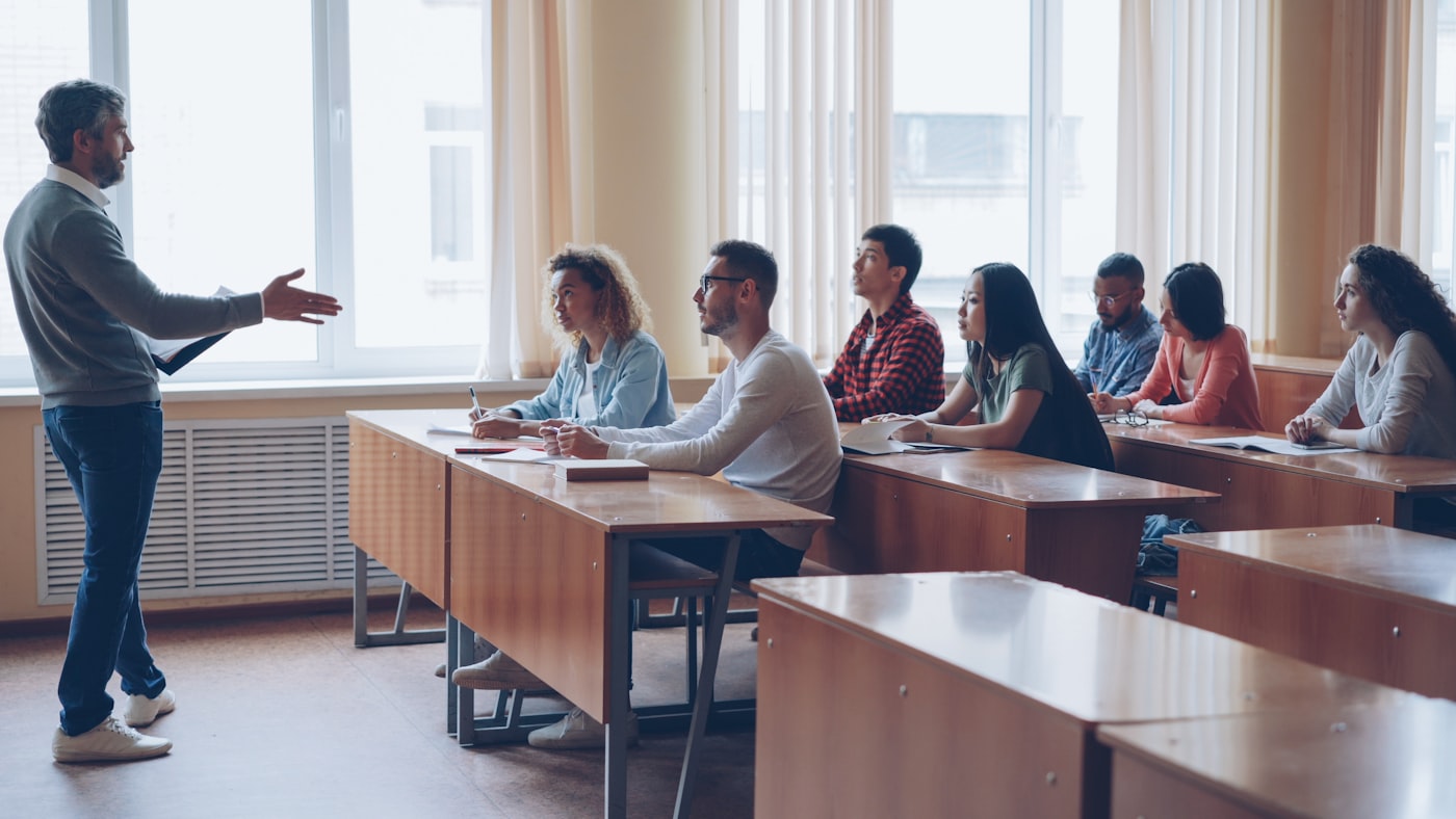 Instructor frente a una sala con estudiantes adultos