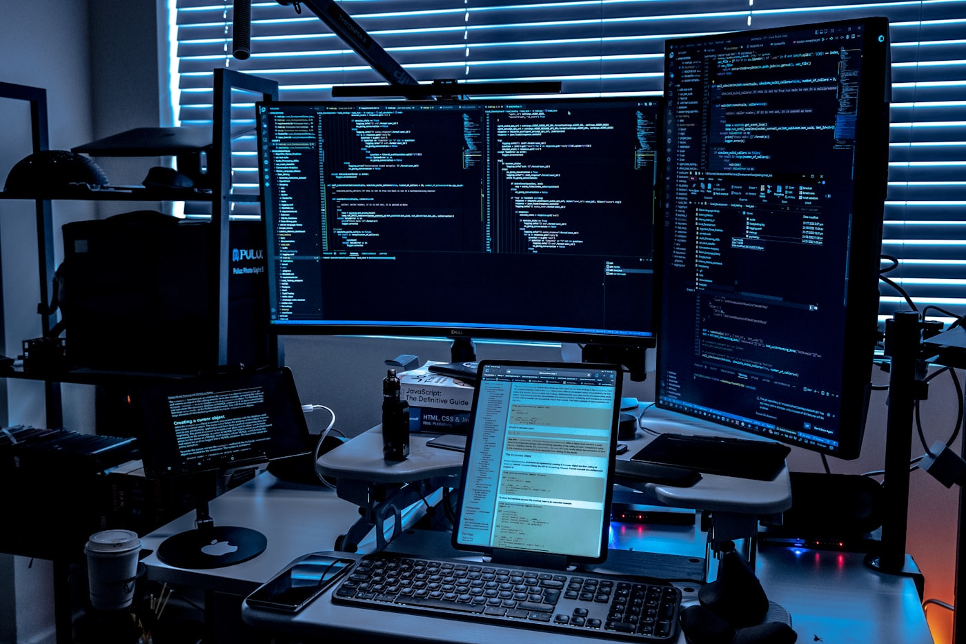 Escritorio con varios monitores mostrando código
