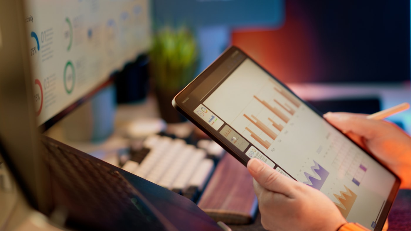 Mano sosteniendo una tablet con gráficos de datos