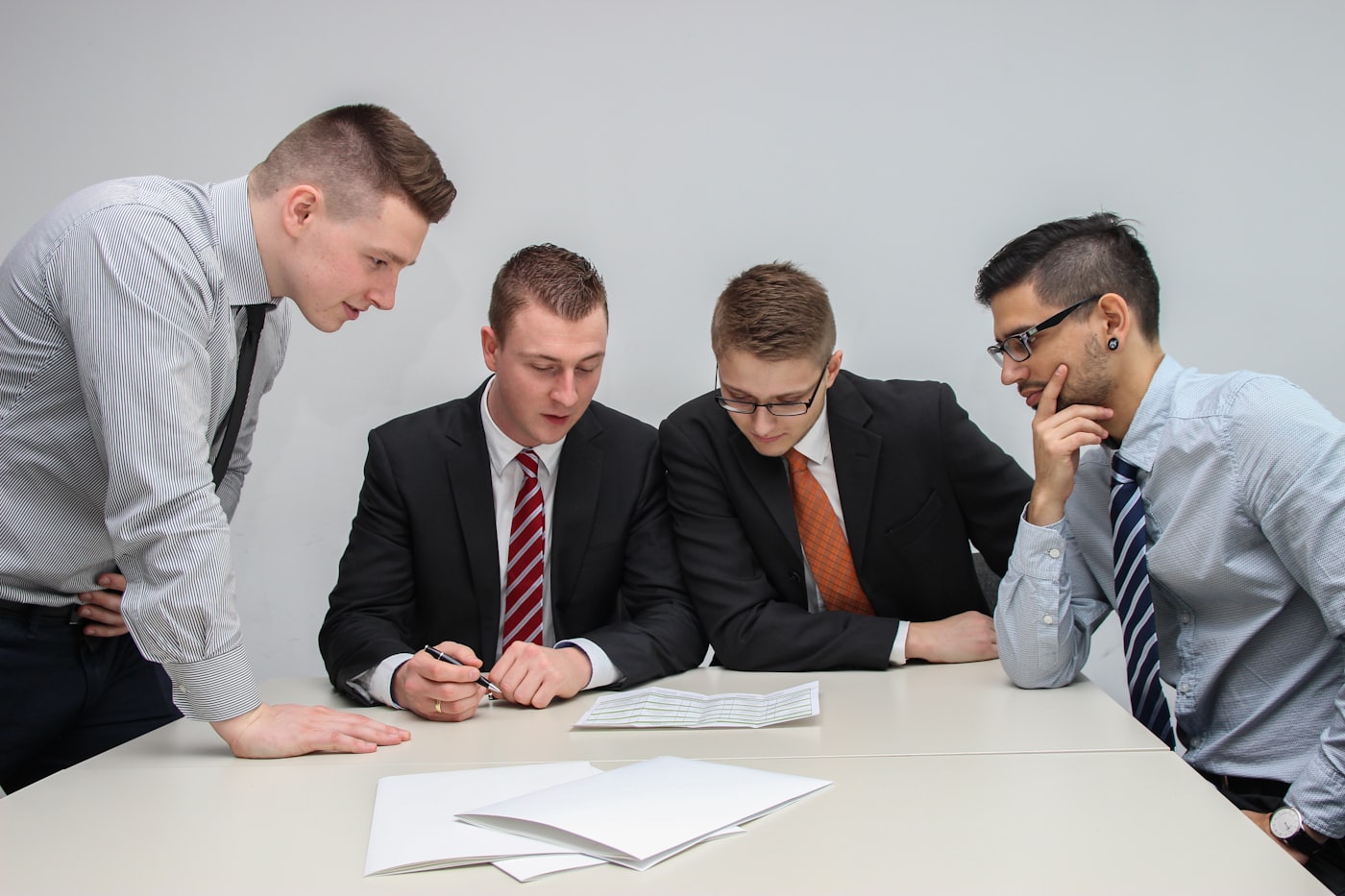 Cuatro personas revisando un documento en una mesa